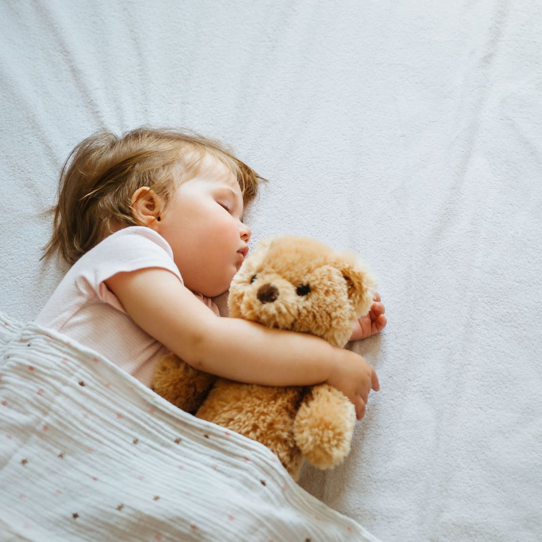 Einschlafhilfe Baby - Kleinkind schläft mit einem Teddy im Arm